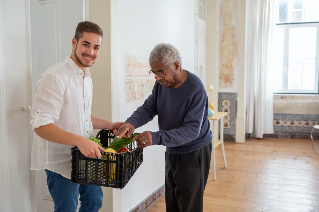 Photo by Kampus Production: https://www.pexels.com/photo/a-man-holding-a-plastic-crater-while-assisting-an-elderly-man-7551587/